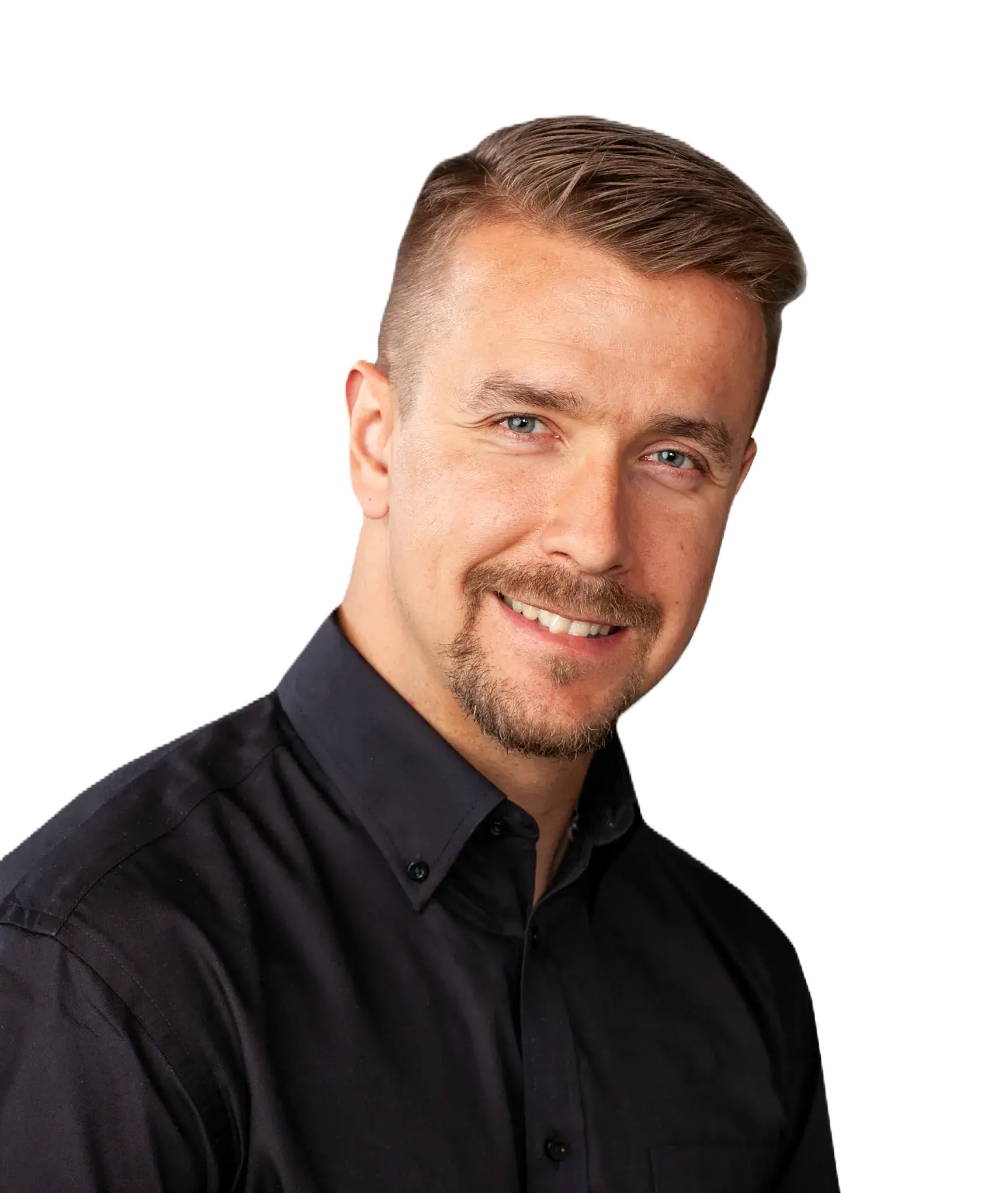Muotokuva hymyilevästä miehestä mustassa paidassa, jolla on vaaleat hiukset ja parta, mustalla taustalla.